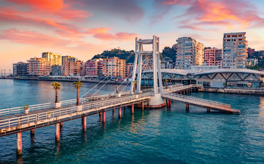 Ez a kép Durrës (Albánia) kikötőjét és a sétányt ábrázolja naplementekor. 